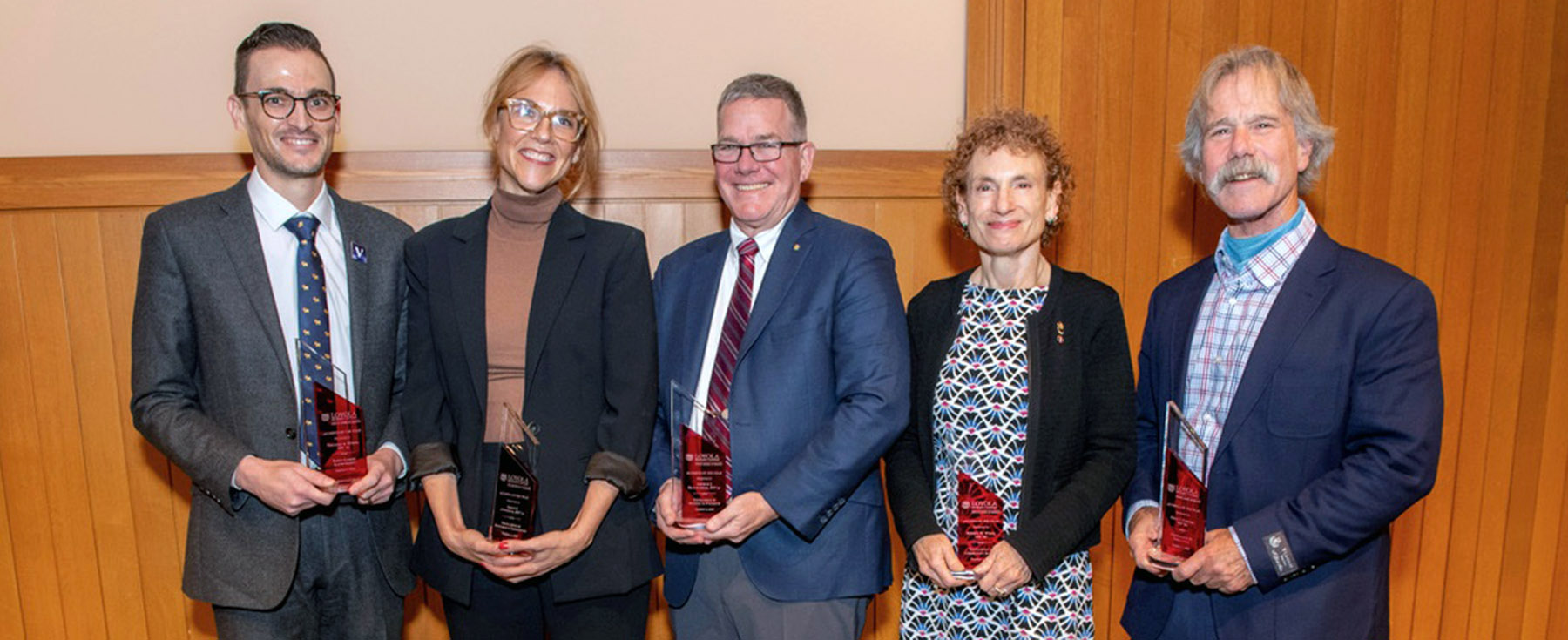 The five Stritch Alumni of the Year Award winners smiling and holding a trophy.